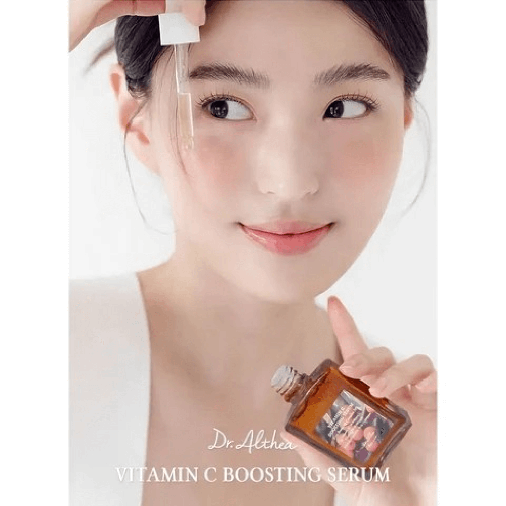 Dr. Althea Vitamin C Boosting Serum with a model applying the serum to brighten skin and reduce blemishes.