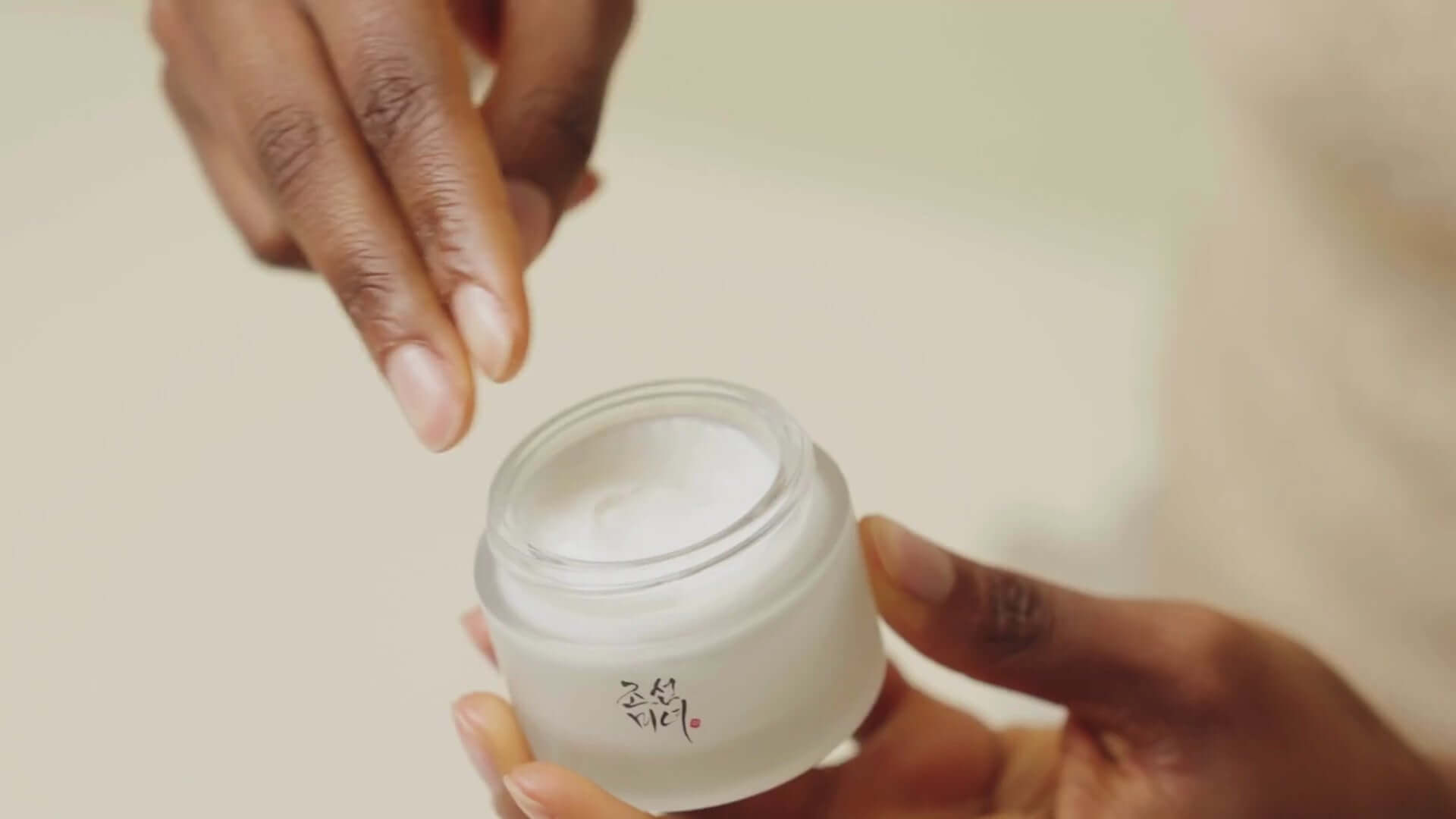 Beauty of Joseon Dynasty Cream 50ml in a jar, showing a person applying moisturizer for healthy, glowing skin.